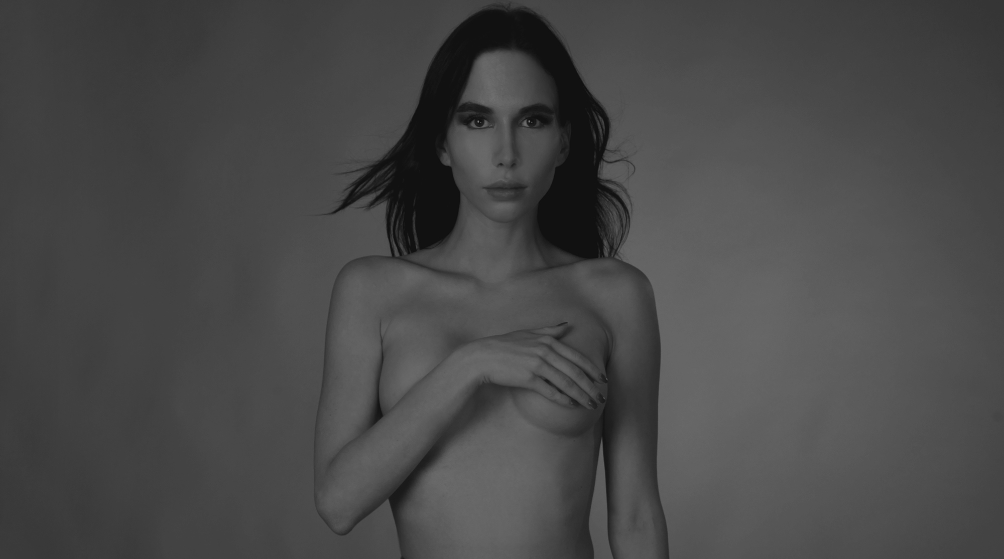 A black and white photo of a topless girl with black hair. A studio photo. was taken at Shalev Man's studio in Prague