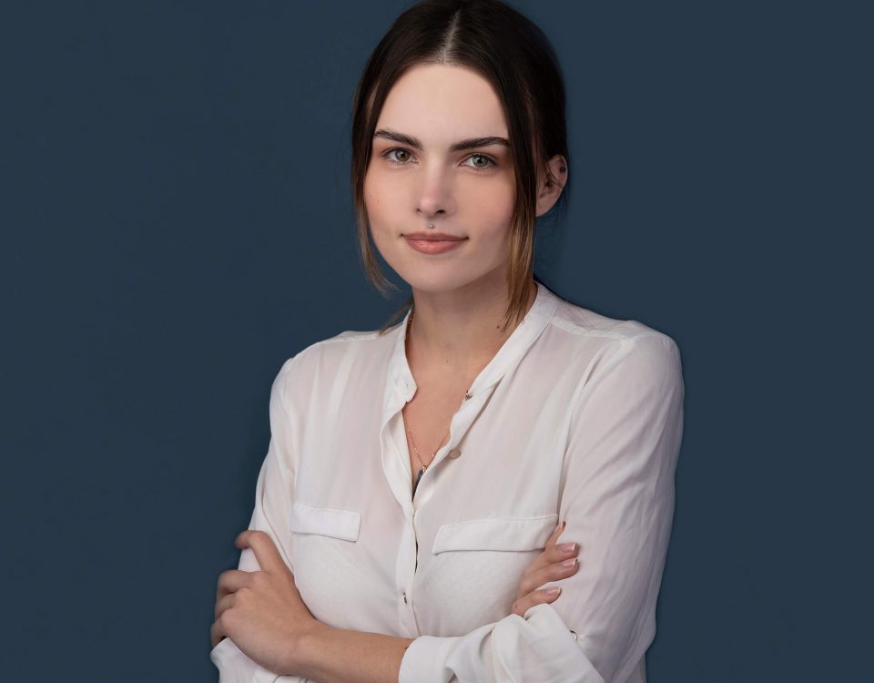 A corporate professional photo by Shalev Man. in the photo a woman with white shirt, crossed hands with a professional look
