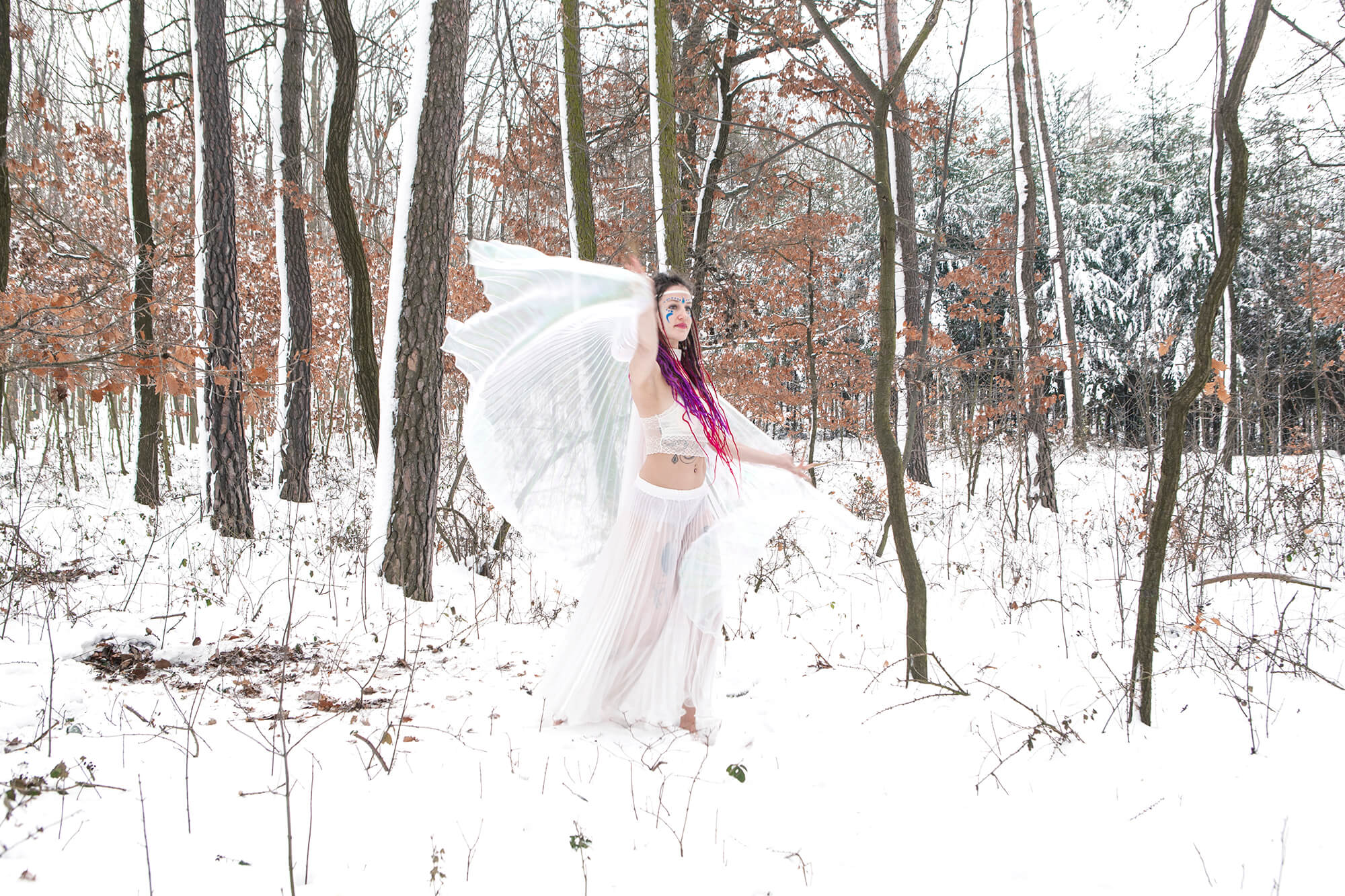 A wintar fairy dancing in the snow, a photo a woman dressed in white as a fairy, dancing in the snow